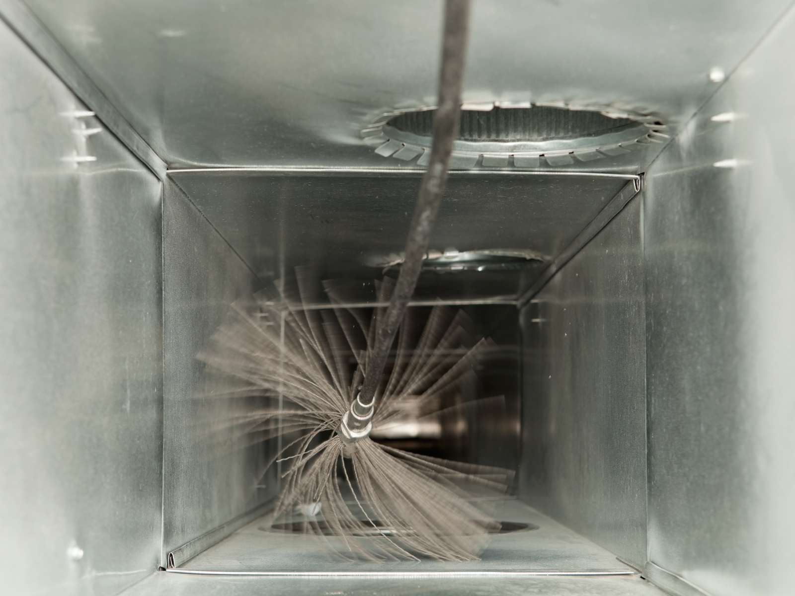 air duct cleaning with professiona cleaning brush. Air duct cleaning brush inside an air duct.